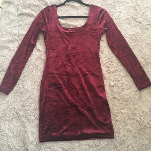 A form fitting maroon velvet dress